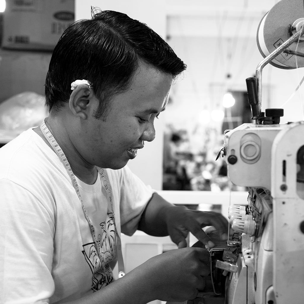 Profile of balinese man smiling at a sewing machine