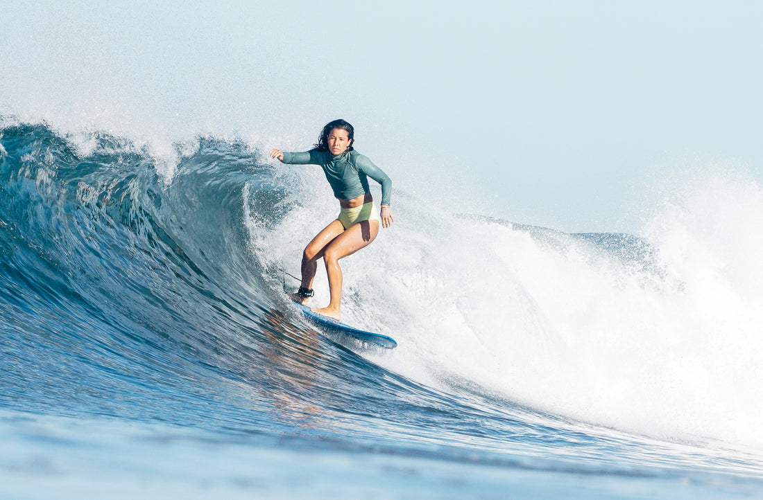 Erika surfing wearing a rash guard and lucky high waisted surf bikini bottoms 