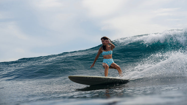 Person surfing on a wave with a clear sky background
