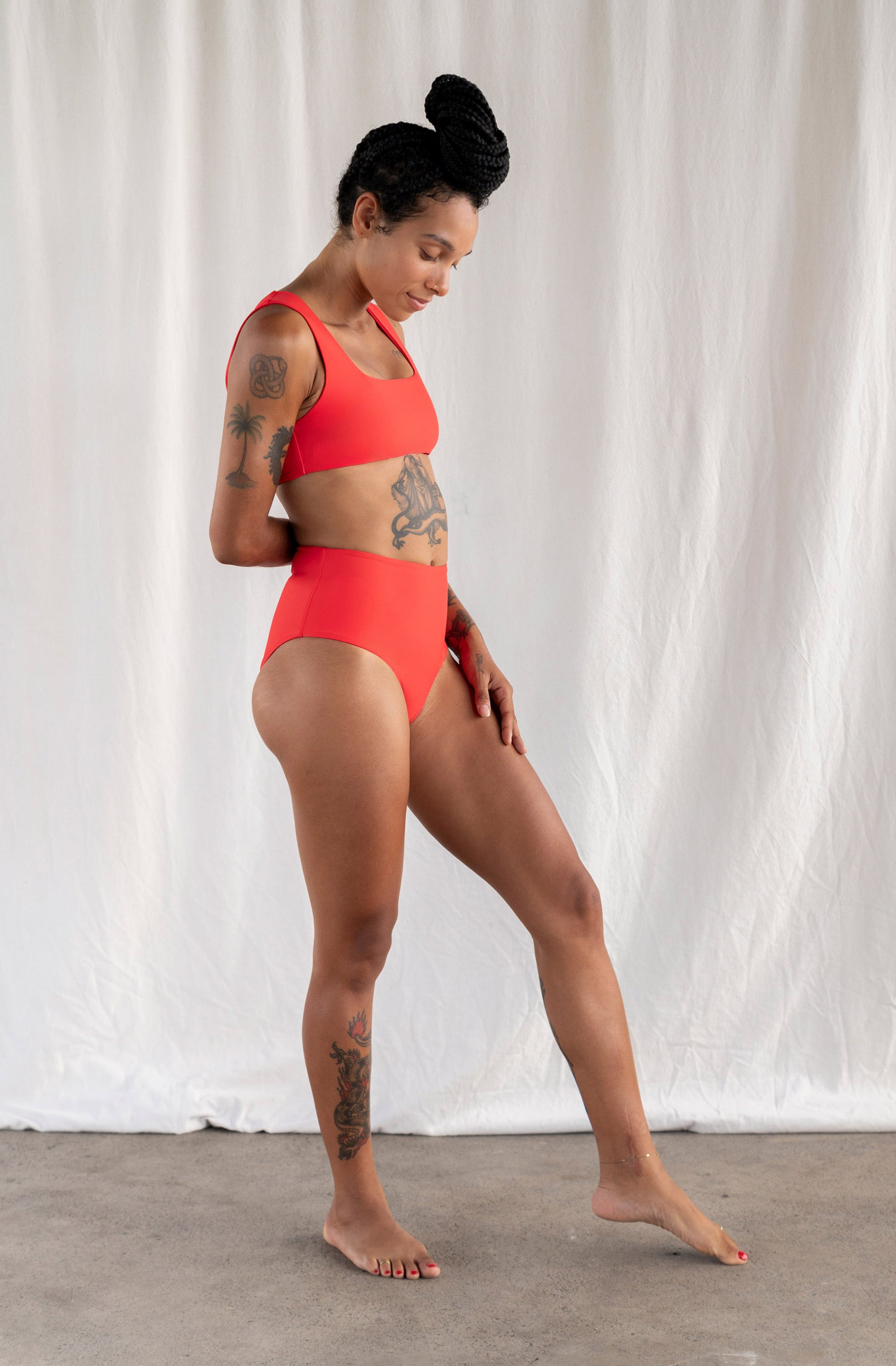 Woman wearing a red swimsuit against a white background