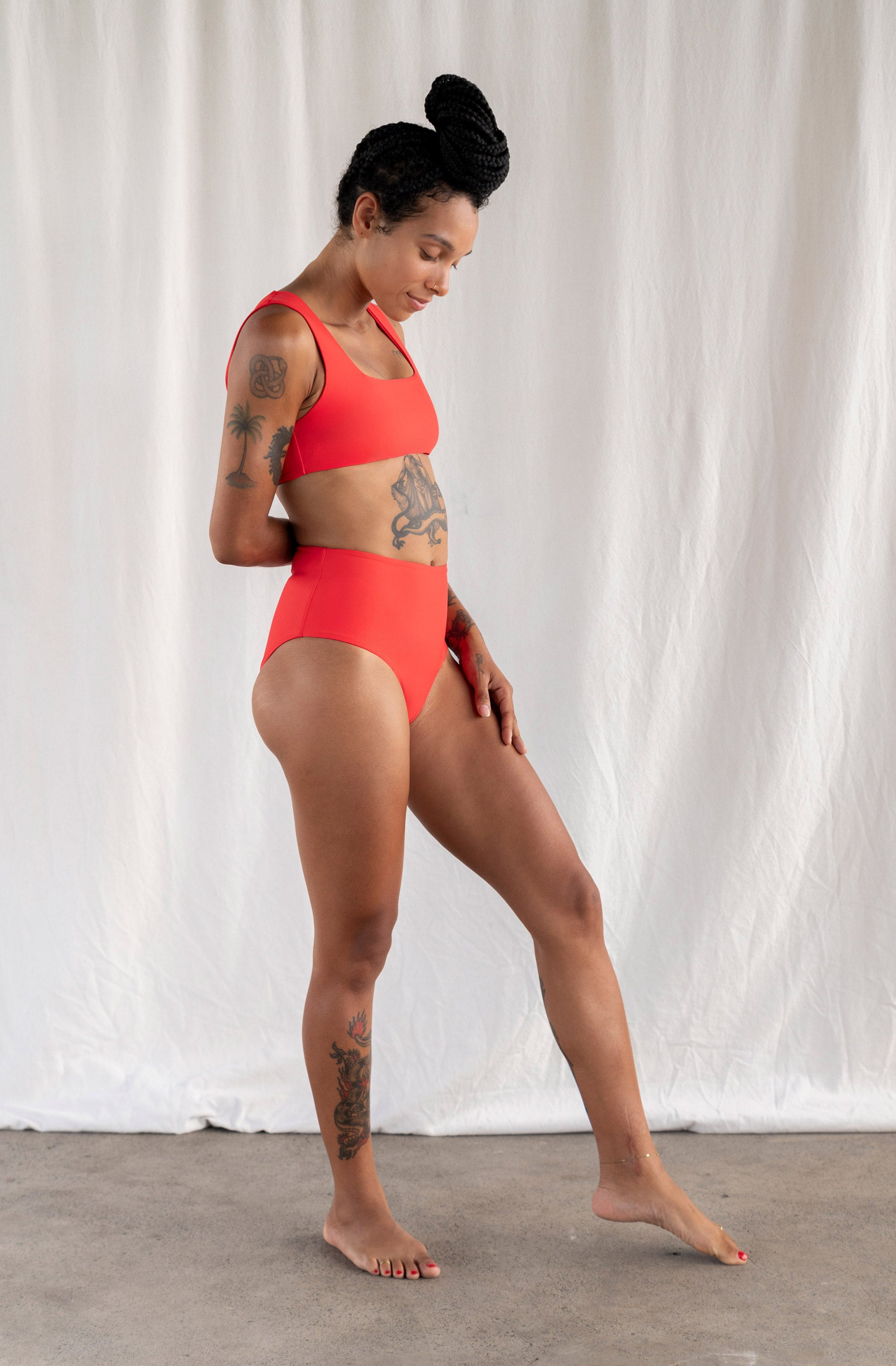 Woman wearing a red swimsuit against a white background