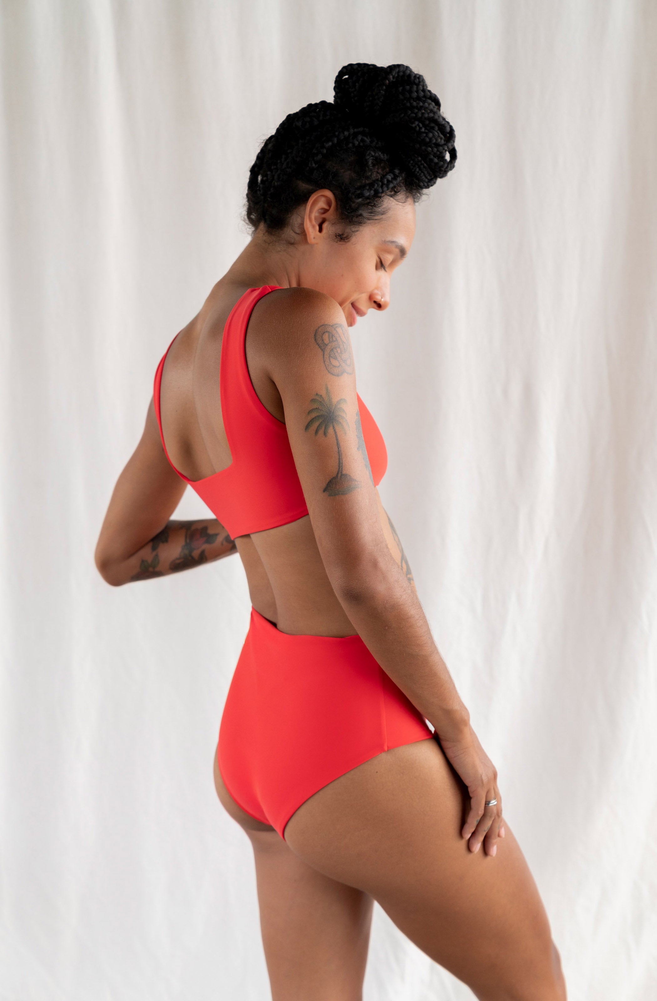 Woman wearing a red swimsuit against a white background