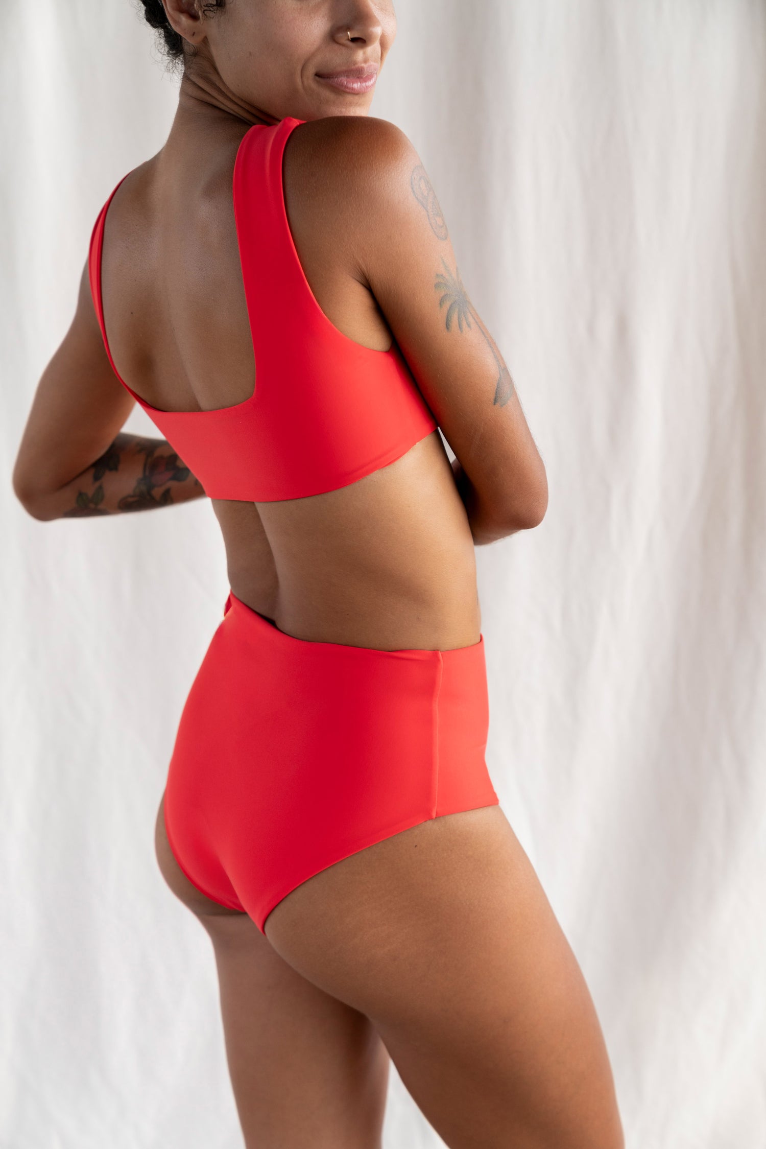 Person wearing a red swimsuit against a white background
