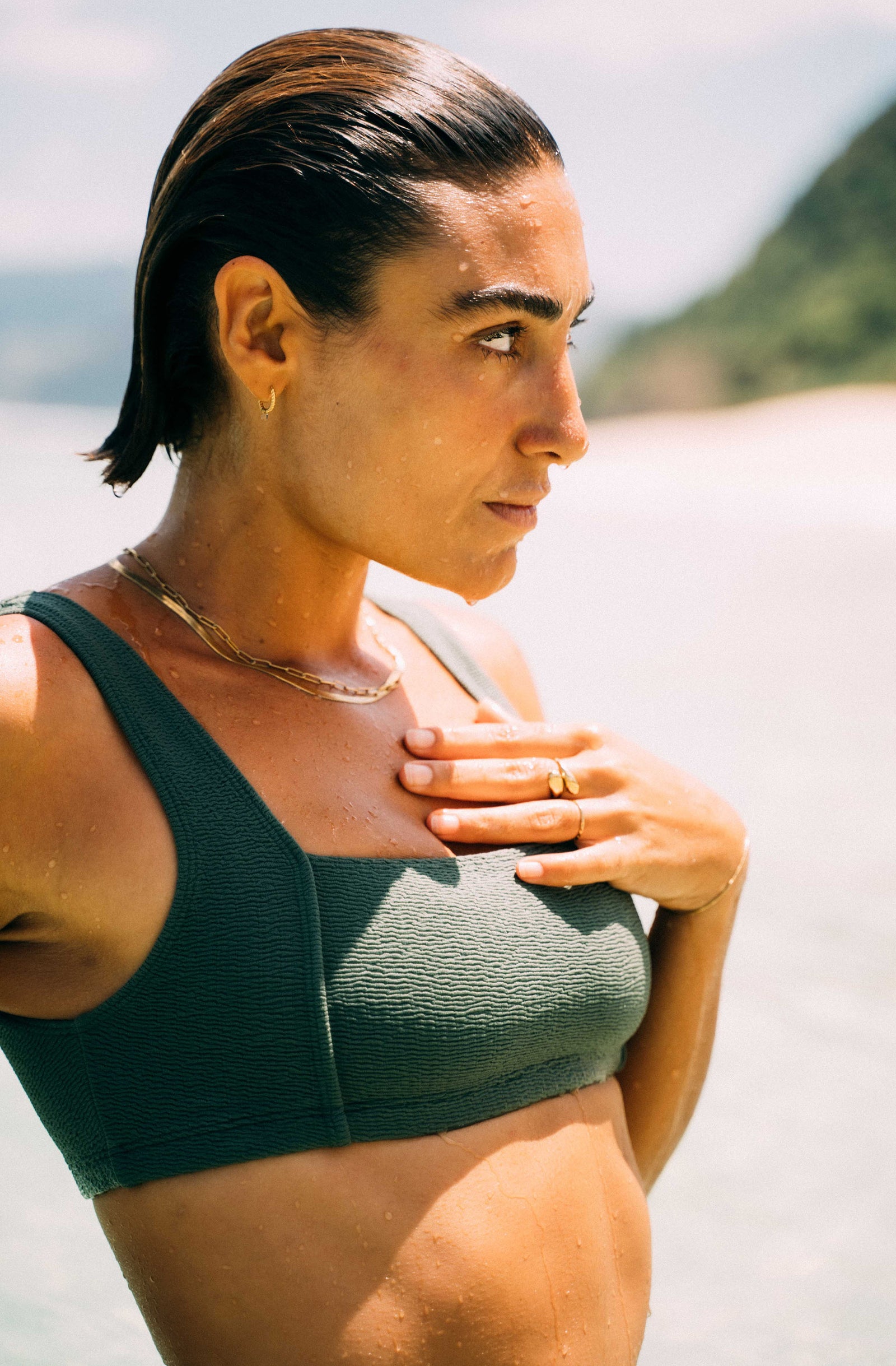Woman wearing a green sports bra on a beach