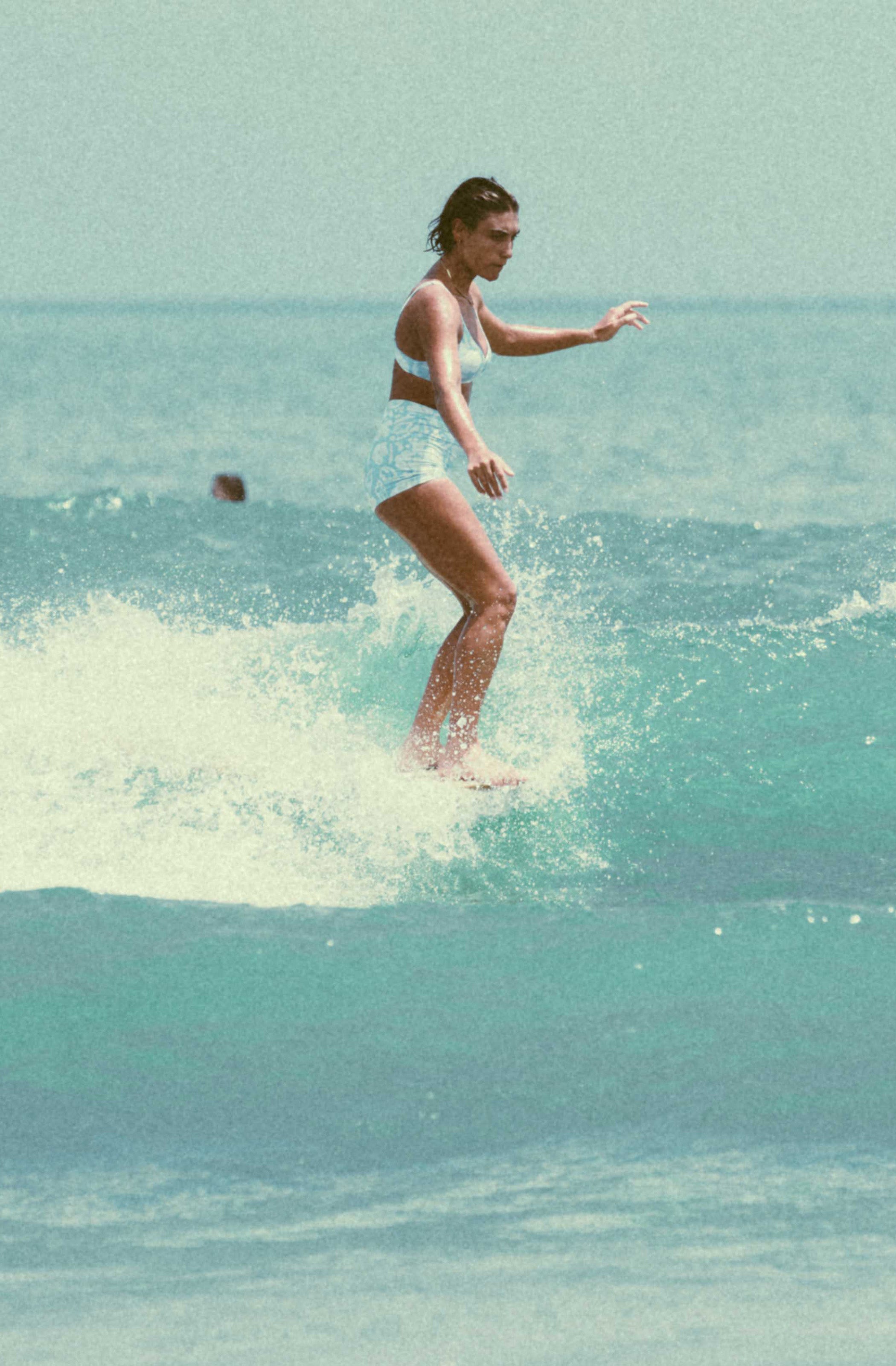 Person surfing on a clear blue ocean