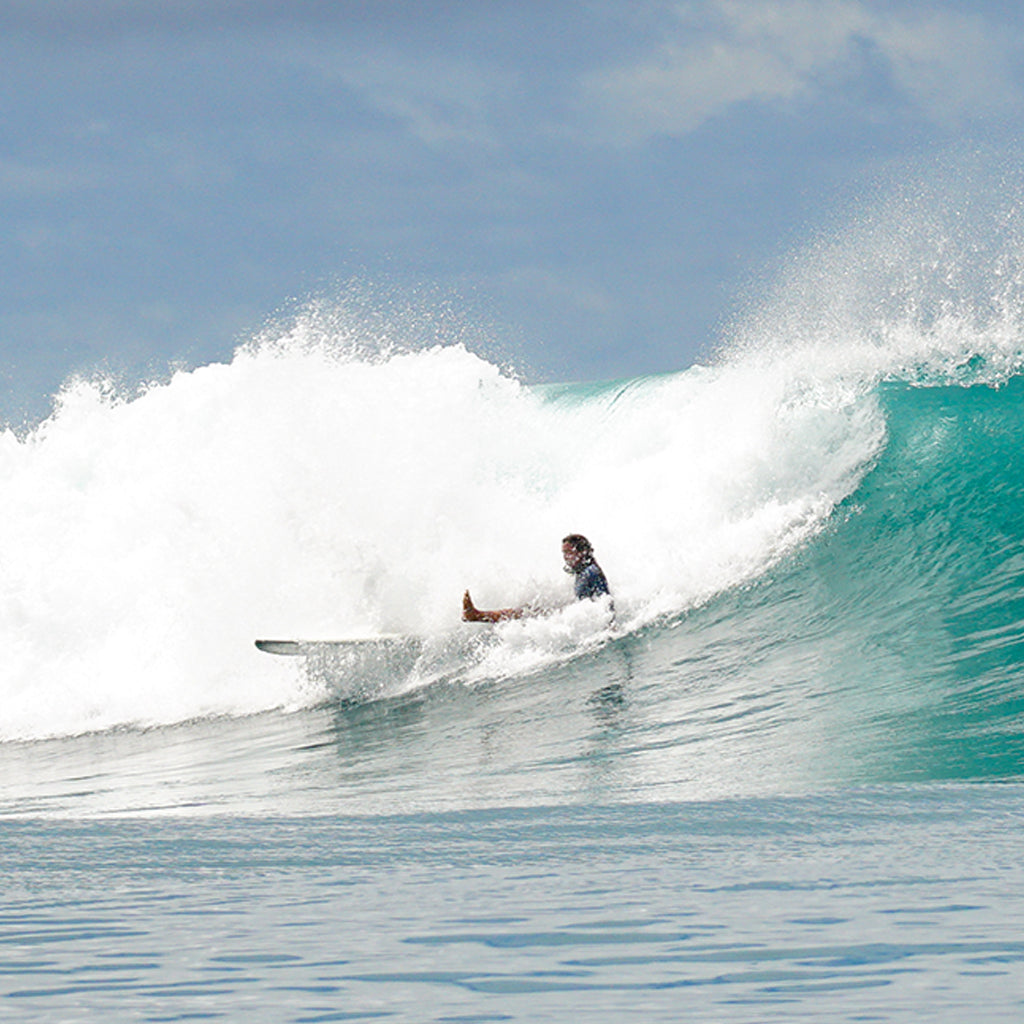 Woman having a wipe out on a surfboard in Indonesia and falling into the wave