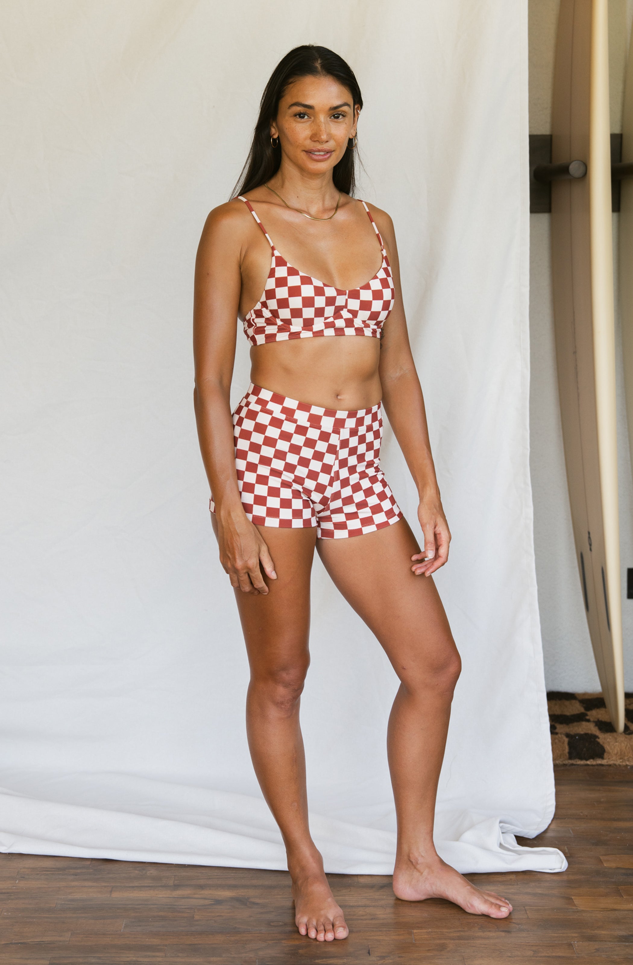 Woman wearing a red and white checkered bikini set against a plain background