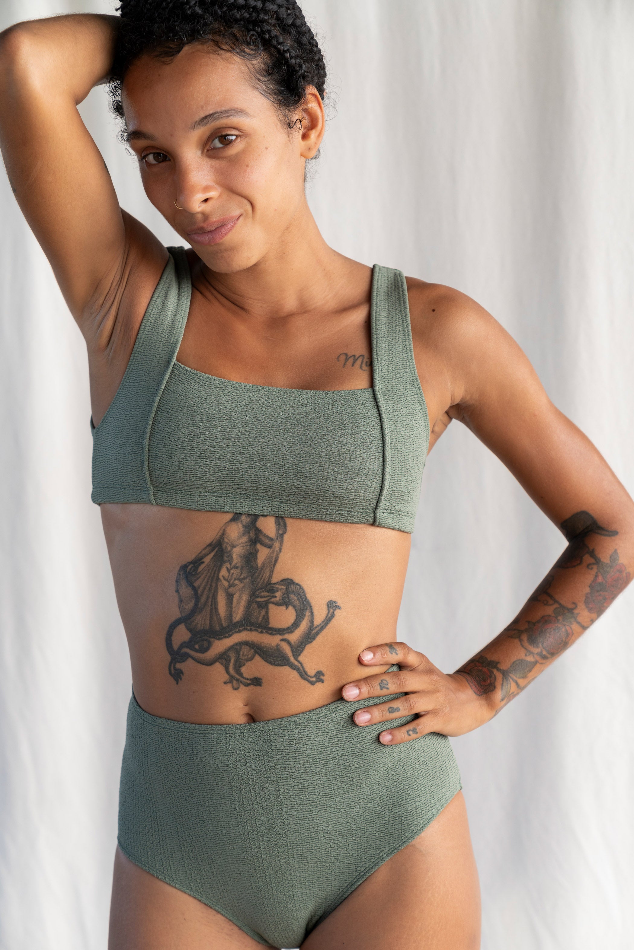 Woman wearing a green bikini set against a white background