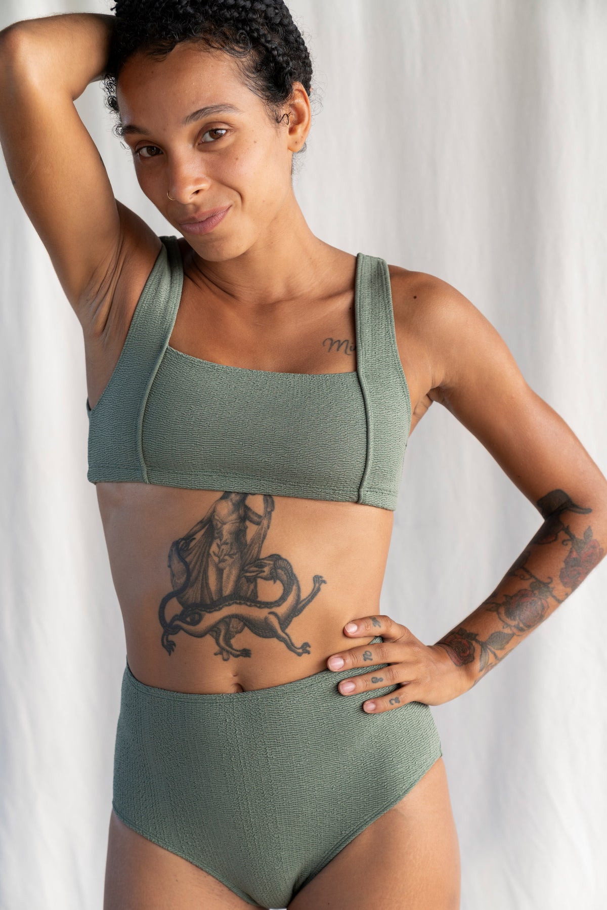 Woman wearing a green bikini set against a white background