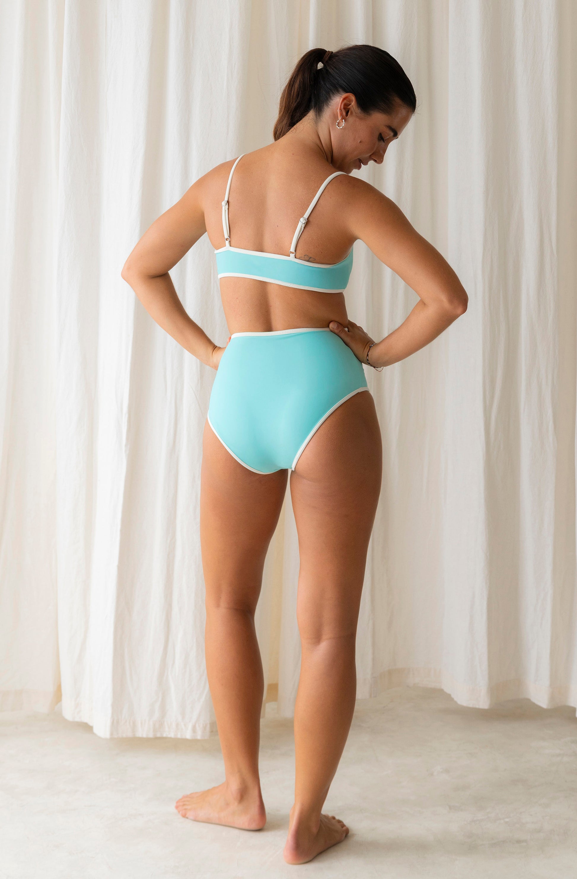 Woman wearing a light blue bikini set against a white background