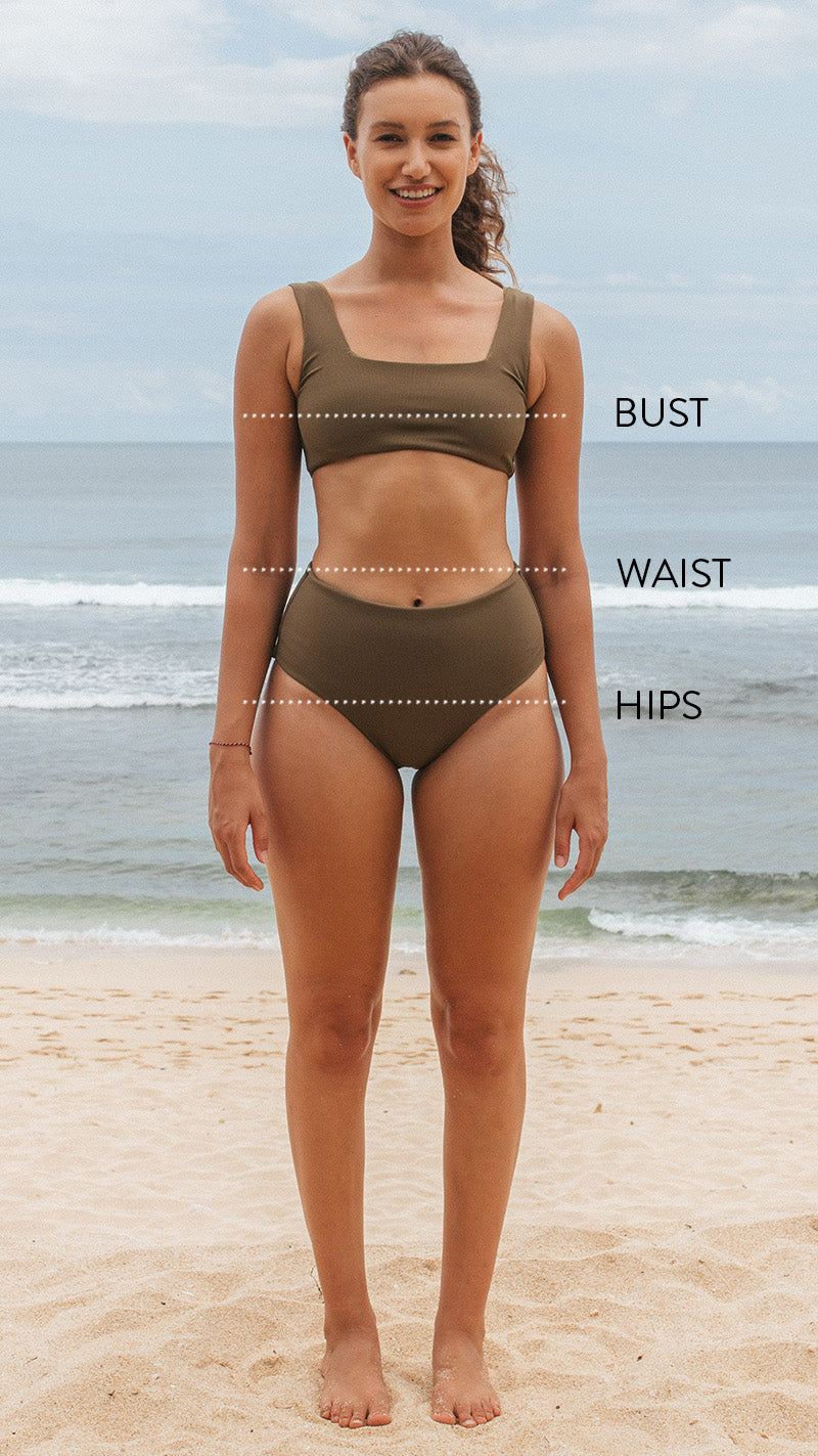Woman standing on the beach wearing a surf bikini top and bottom