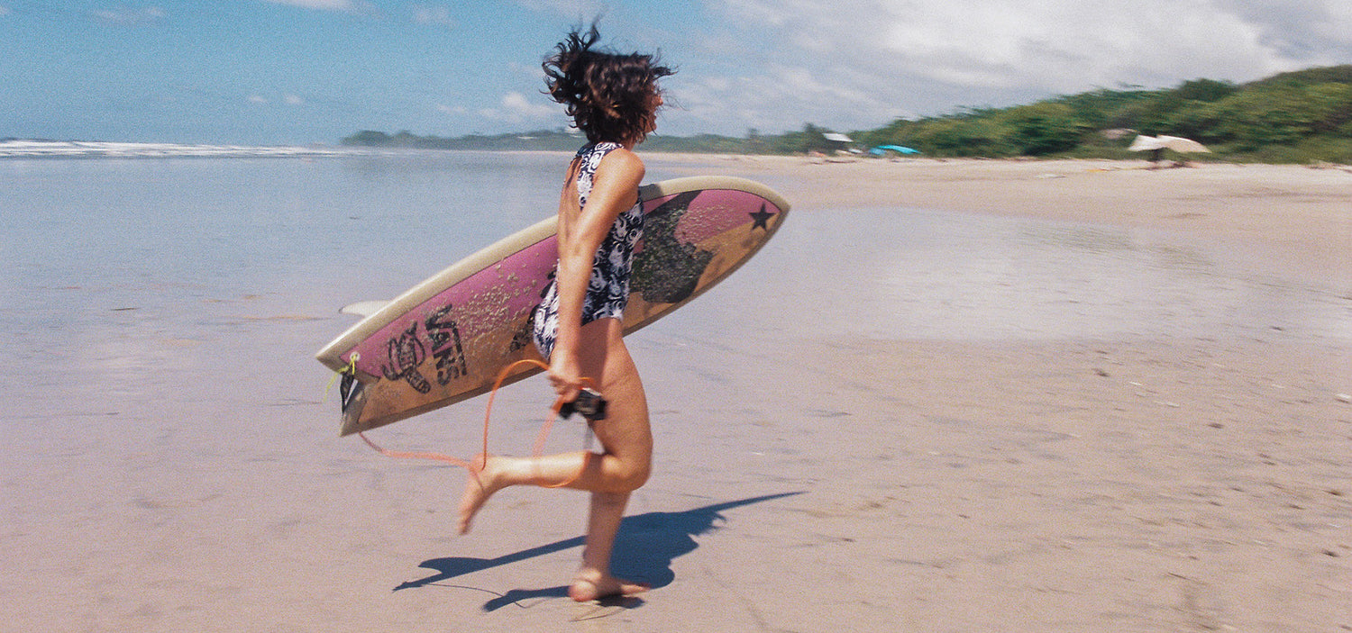 woman running with surfboard