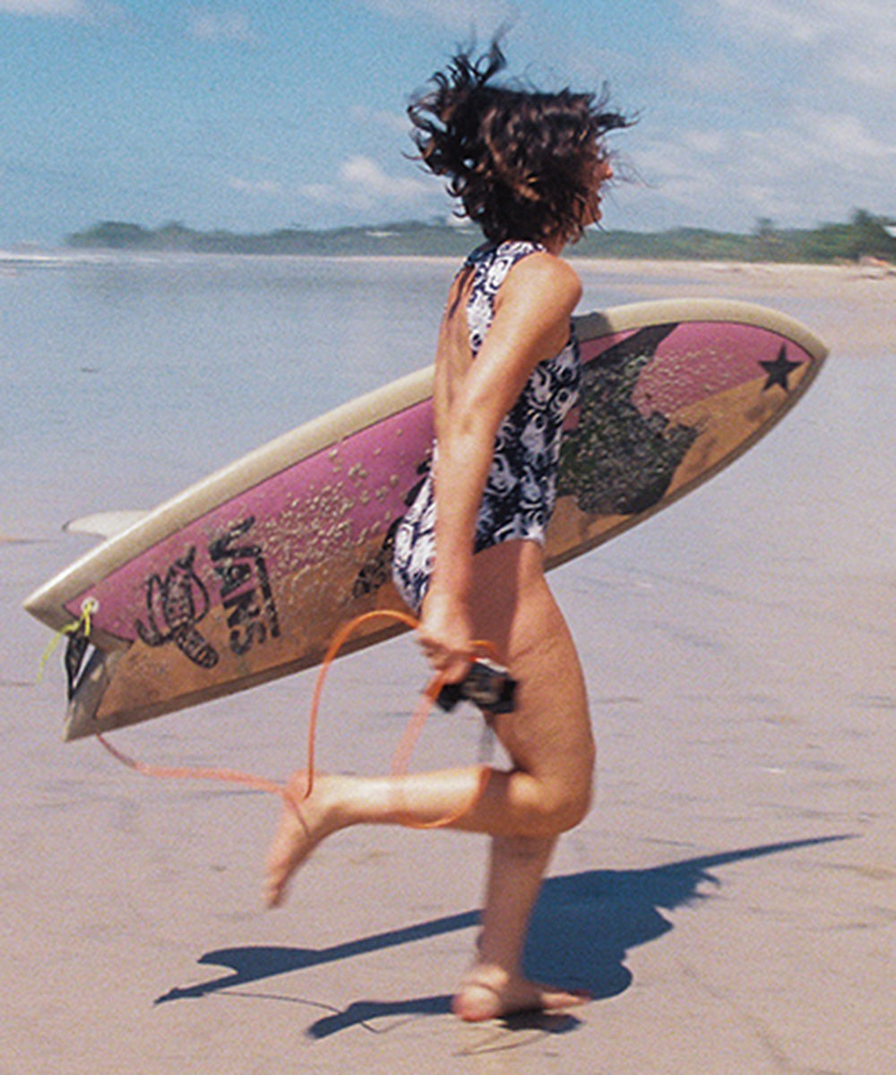 Woman running with surfboard
