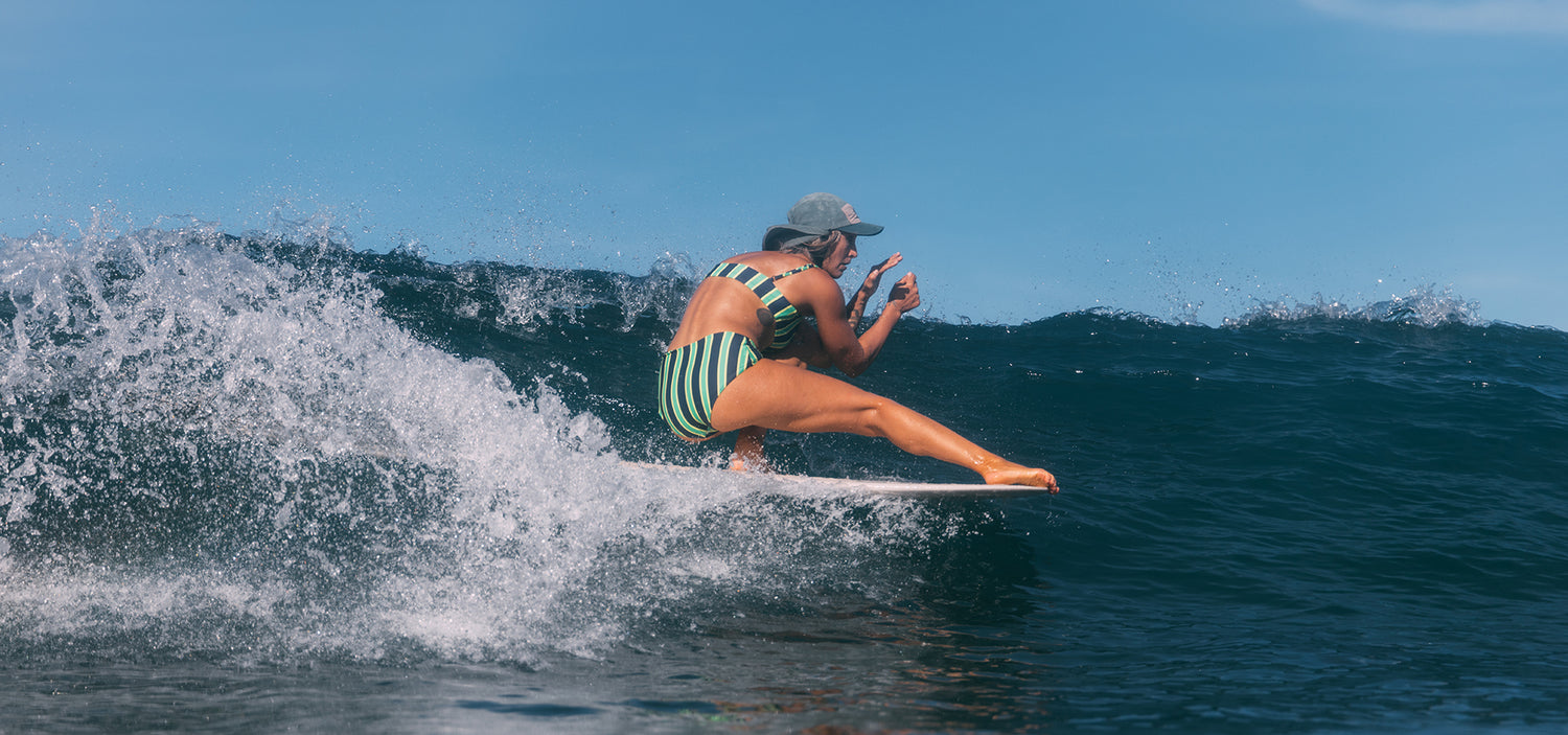 Person surfing on a wave with a clear blue sky