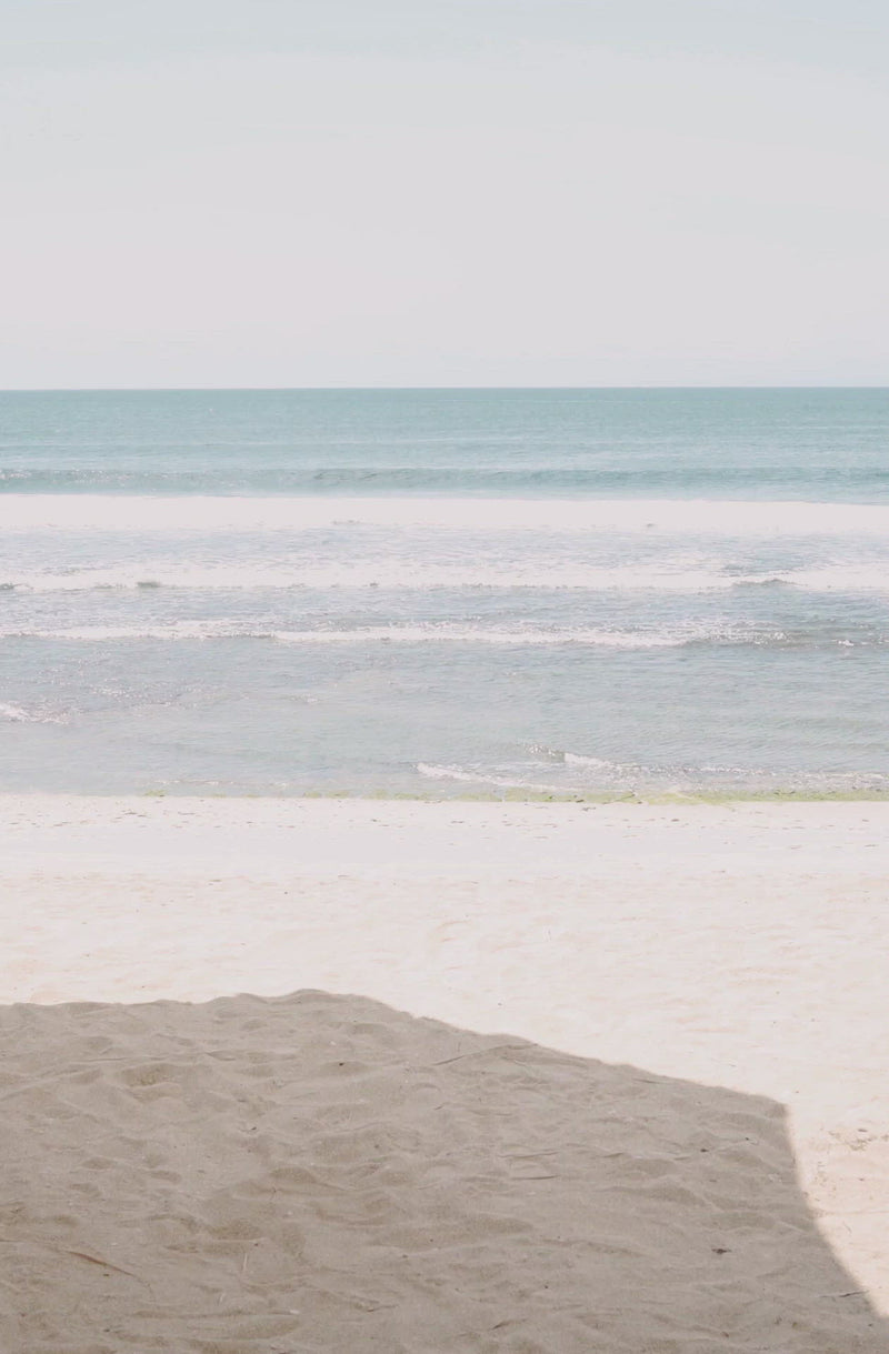 Woman standing in front of ocean wearing Surf_Bikini_Bottom_Lolita_Guava_Eco_Rib