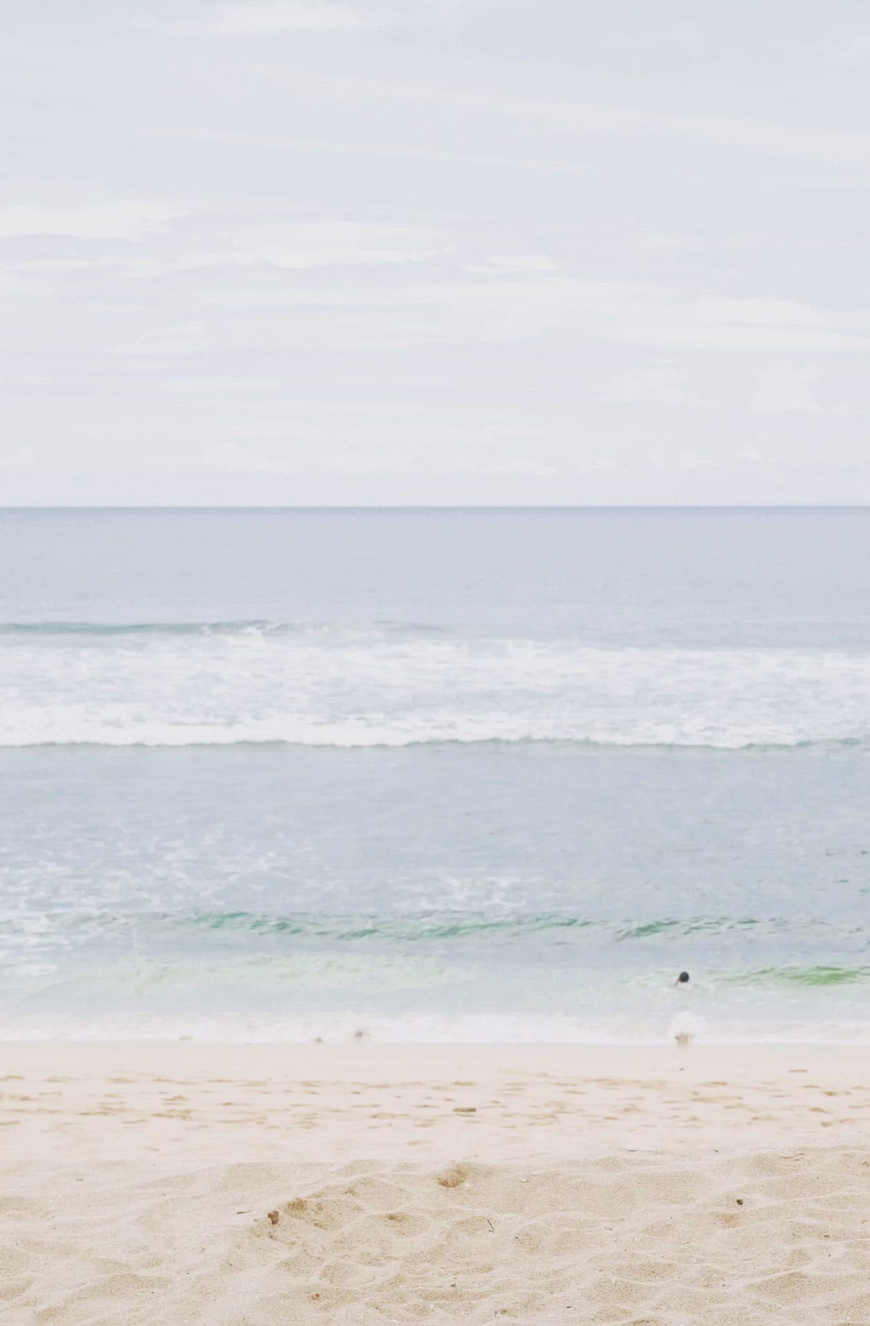 Load video: Woman standing in front of ocean wearing    Surf_One_Piece_Marigold_Sangria_Red