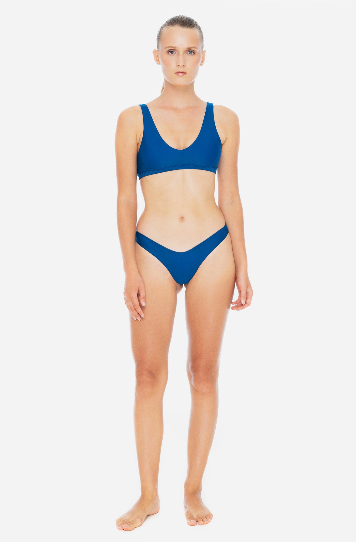 Front view of a woman modelling a surf bikini top and a surf bikini bottom in lake blue.