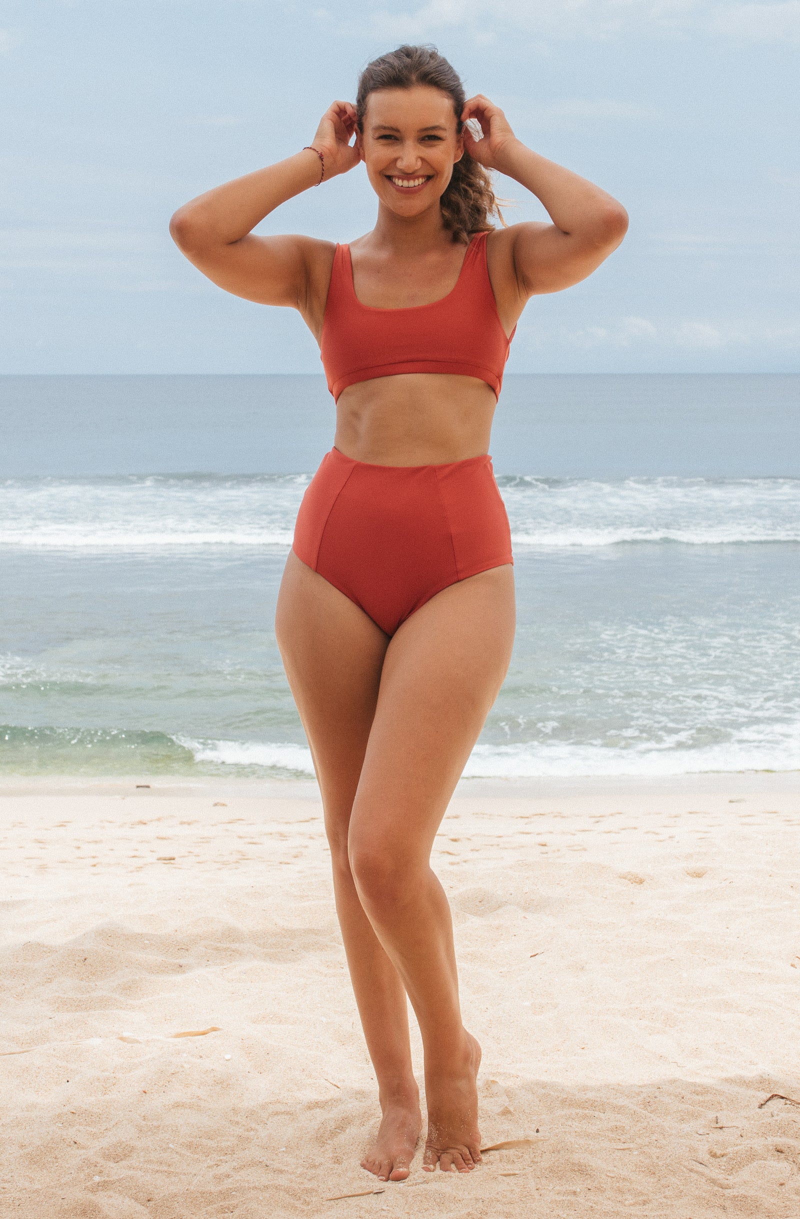 Woman doing a carving turn in the lori bikini top and Alice bikini bottom in Burnt Sienna