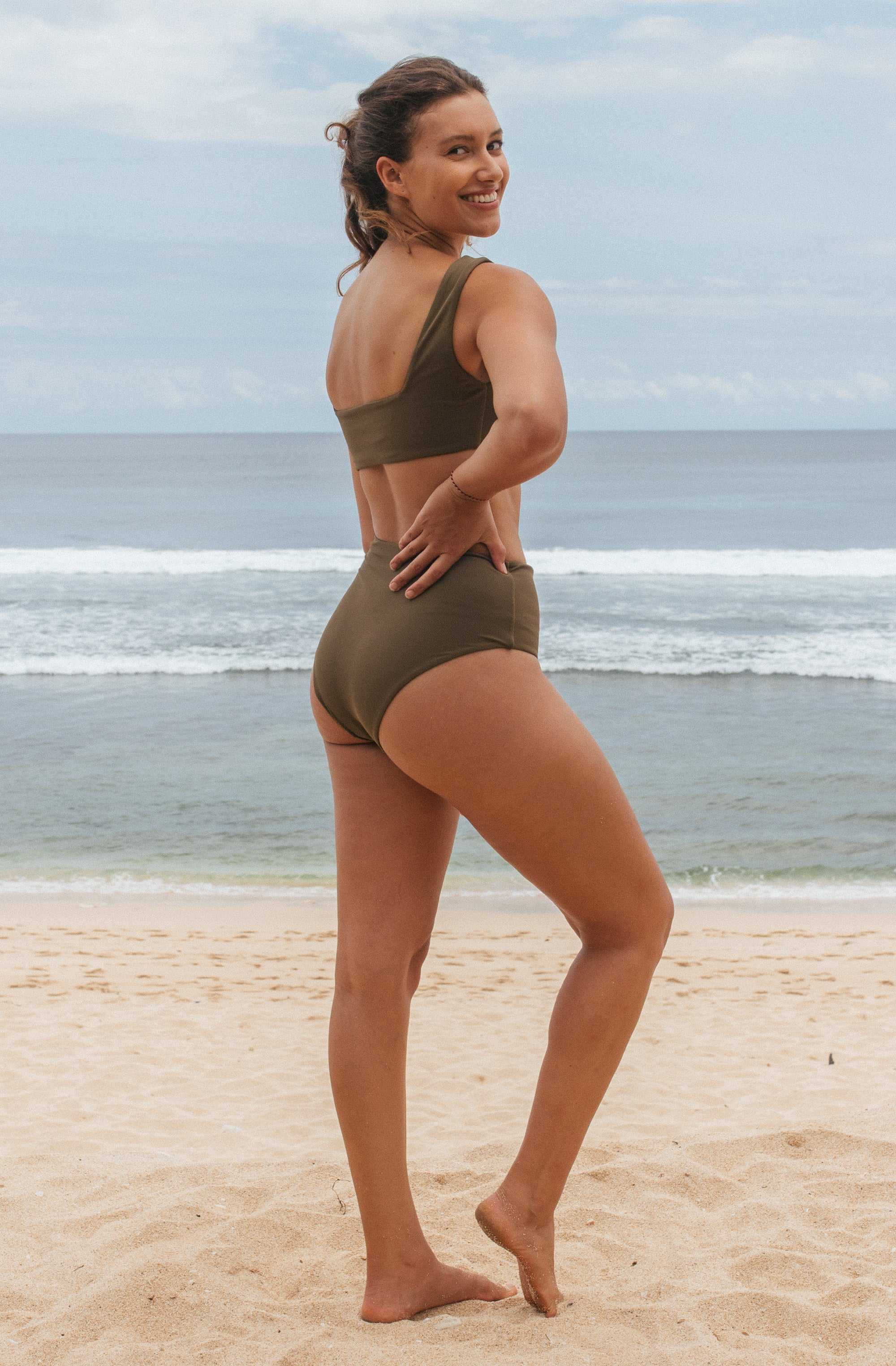 Woman standing in front of ocean wearing Surf_Bikini_Bottom_Kennedy_Caper_Eco_Rib