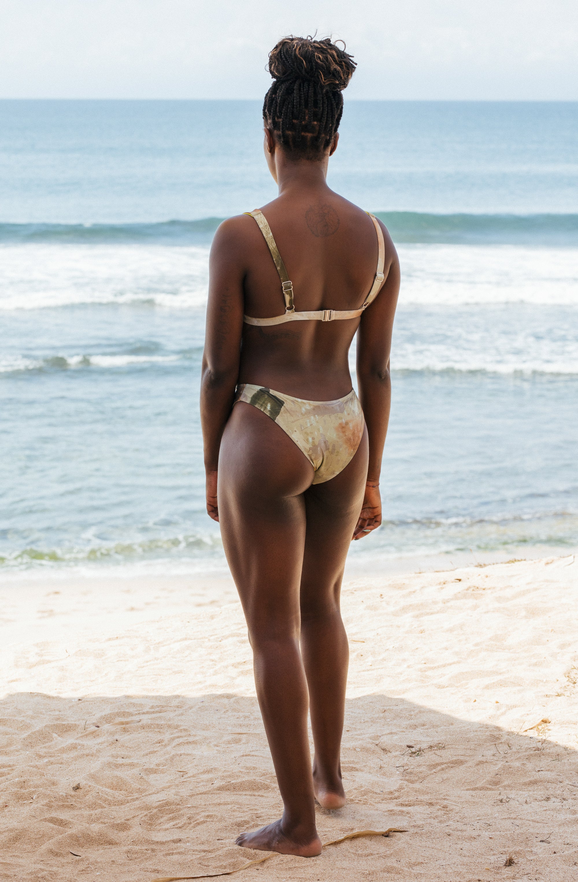 Woman standing in front of ocean wearing Surf_Bikini_Top_Kiyo_Sea_Foam_Camo