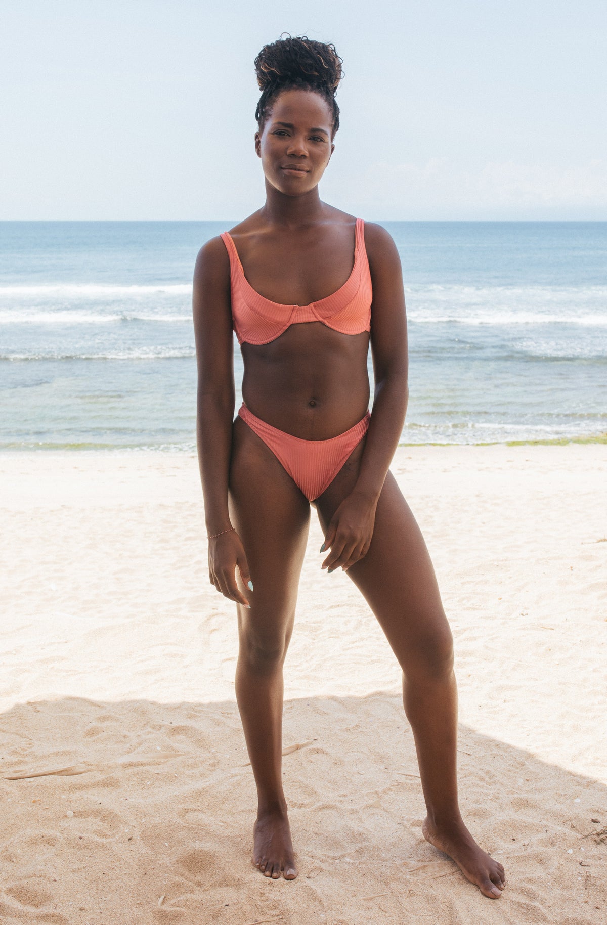 Woman standing in front of ocean wearing Surf_Bikini_Top_Rita_Guava_Eco_Rib