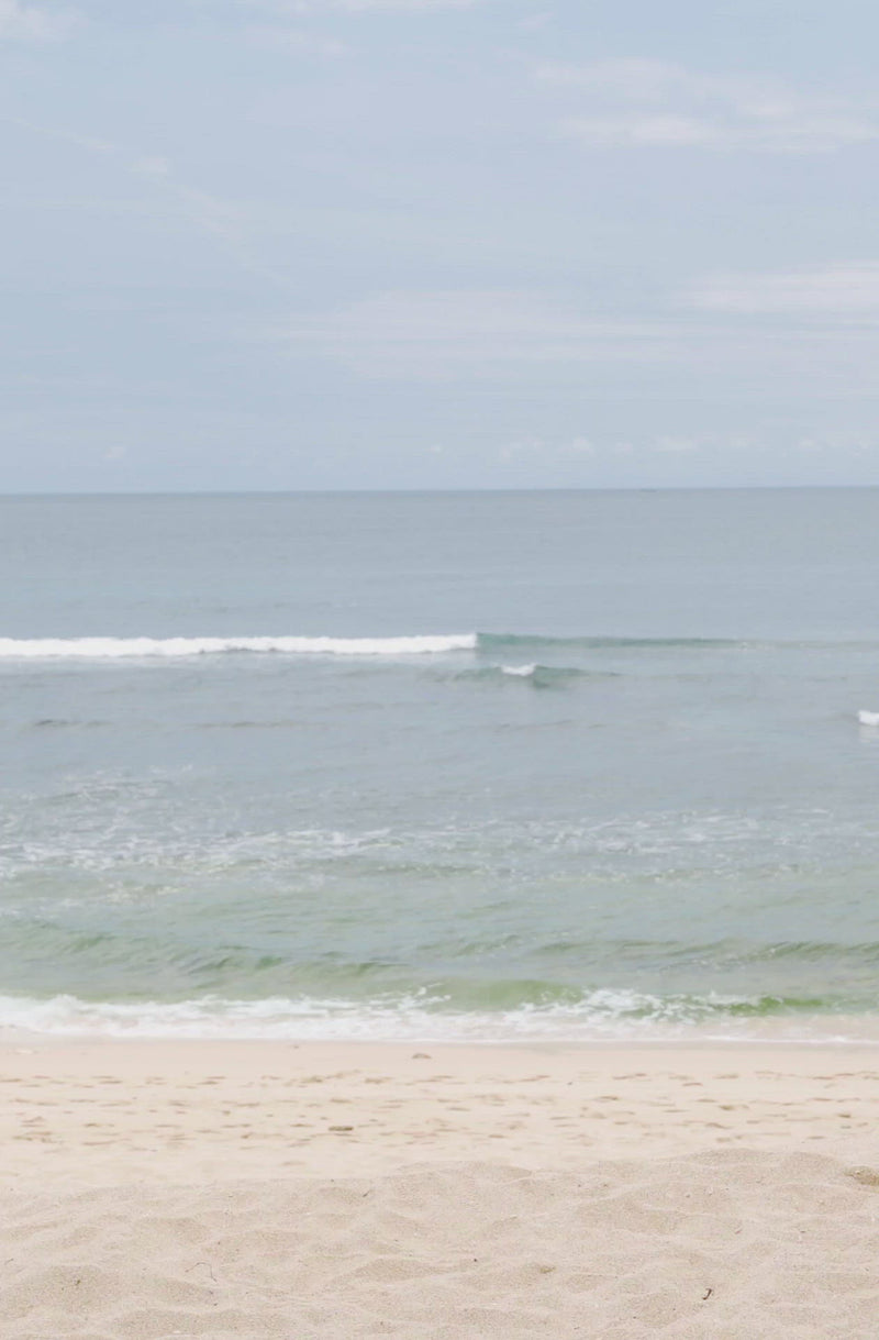 Woman standing in front of ocean wearing Surf_Bikini_Bottom_Lolita_Guava_Eco_Rib