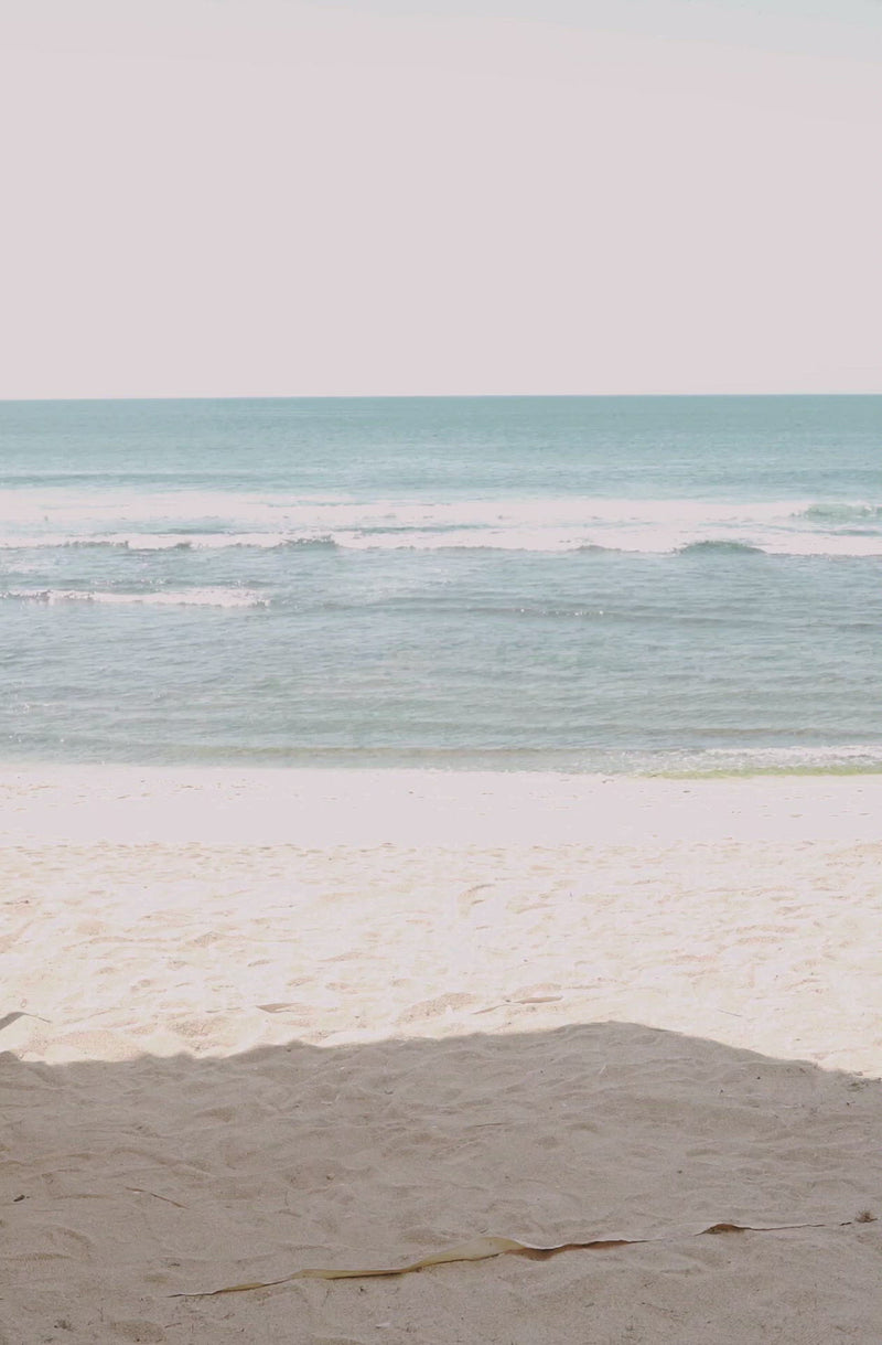Woman standing in front of ocean wearing Surf_One_Piece_Malibu_Burnt_Ivory